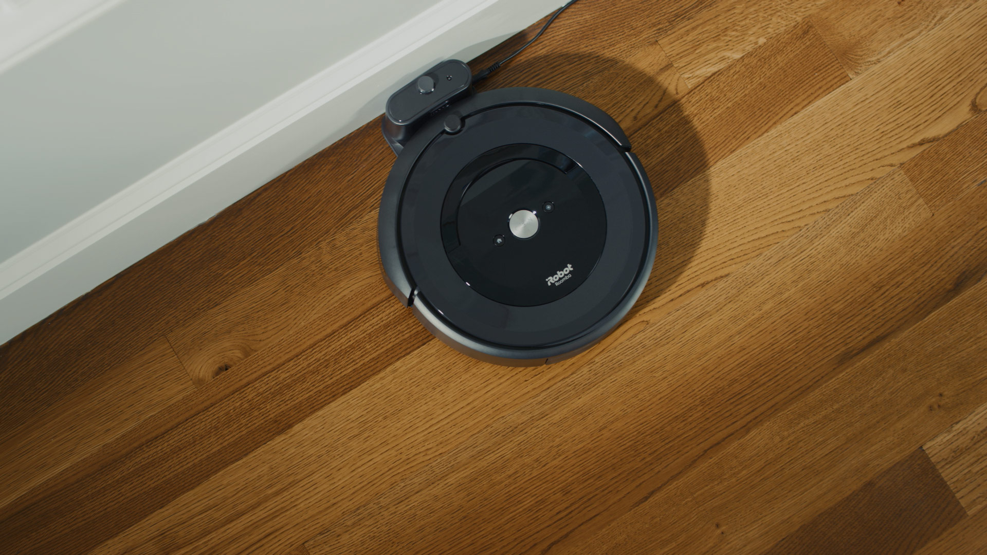 A iRobot Roomba i7 on a hardwood floor.