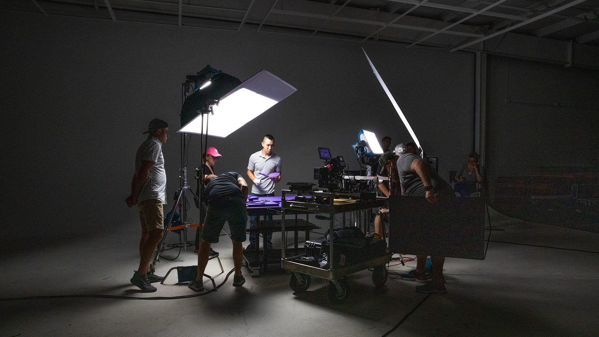 A behind-the-scenes photo of a commercial shoot in the studio. Many lights can be seen illuminating the tabletop.