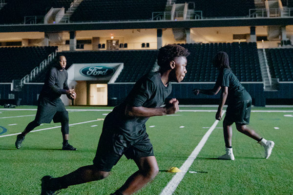 Athletes practicing in the Dallas Cowboys practice stadium.